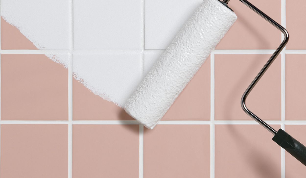 Pink tile being painted with white primer